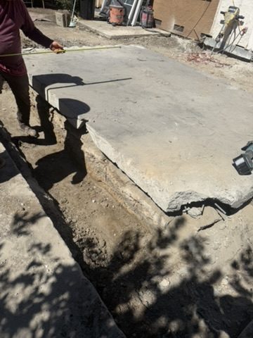 Tape measure held against the cut slab edge to document its thickness